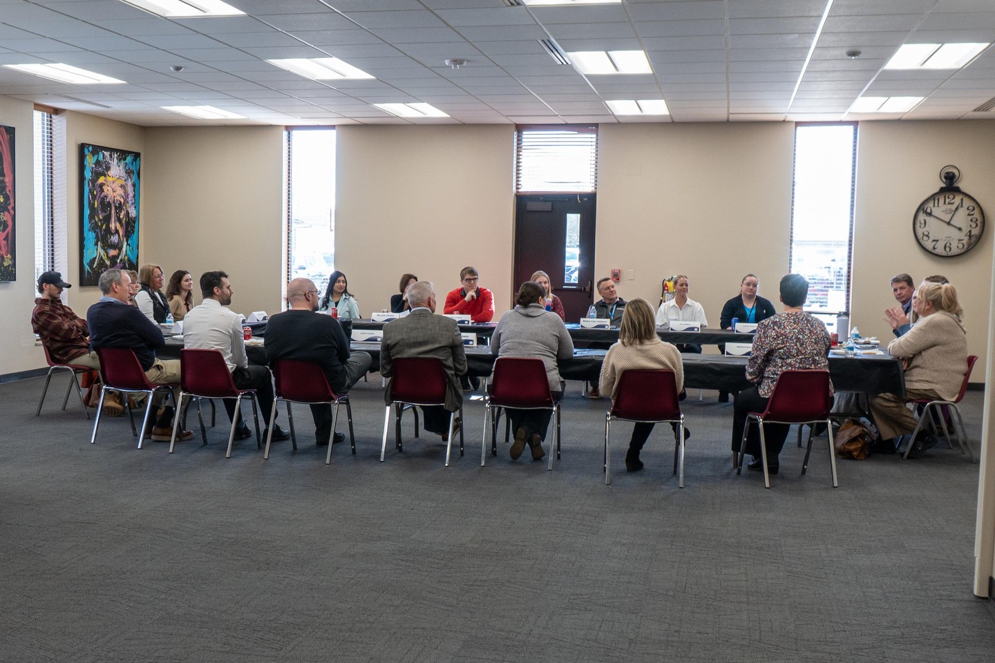 ACF team members and community partners seated around tables during a meeting